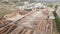 Aerial view of operating wood factory at rural area with tractors circulating in