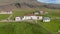 Aerial view orbit around typical building in countryside of Iceland with small church and cemetery. Birds eye flying