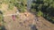 Aerial view of the organized gathering of people near a large campfire in a pine forest