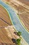 Aerial view over agriculture preparing vegetable fields with road through