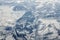 Aerial view over clouds top to snow covered rivers, fields and roads, winter fresh frosty air