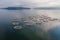 Aerial view over a fish farm with lots of fish enclosures on cages