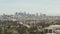 Aerial: view over Los Angeles, California with downtown in background and beautiful rich green trees and residential