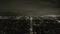 AERIAL: View over Los Angeles at Night with Wilshire Boulevard Glowing Streets and City Car Traffic Lights