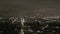 Aerial: view over Los Angeles at night with Wilshire boulevard glowing streets and city car traffic lights