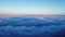 Aerial view over the mountains with sea of fog during morning sunrise in blue sky. Sea of clouds around mountain peaks at sunrise.