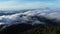 Aerial view over the mountains with sea of fog during morning sunrise in blue sky. Sea of clouds around mountain peaks at sunrise.