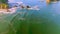 Aerial view over the ocean, tilting up and flying forward revealing sea stacks and Three Arch Rocks just after sunrise on a sky bl