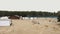 Aerial view over sand beach. People laying on beanbags, playing sport games