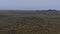 Aerial view over the south of Reykjanes, Iceland with landscape of moss covered lava fields with winding road and pipeline.