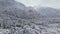 Aerial view of a panorama forest in a winter cloudy day. Beautiful winter nature of spruce and pine in the snow. Flying