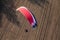 Aerial view of paramotor flying over the harvest field