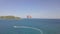 Aerial view parasail flying over blue sea pulled boat. Parasailing in sea bay and green island landscape drone view