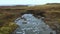 Aerial view : passing over a bridge in the mountains, following river circuit, stone bridge.