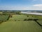 Aerial view of a patchwork of farm fields in the Suffolk countryside with the River Deben in the distance