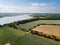 Aerial view of a patchwork of farm fields in the Suffolk countryside with the River Deben in the distance