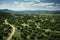 Aerial view of paved road in summer valley with mountains and trees - scenic landscape photography