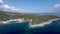 Aerial view of peninsula with trees and rocks, next to a small beach in Pefkohori Halkidiki, Greece, circular movement by drone