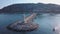 Aerial view of people walking near the small lighthouse standing in the end of the stone pier surrounded by seawater