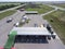 Aerial view at petrol station with trucks, passenger cars filling gas, it is located between two highways, plain terrain