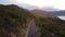 Aerial view of a picturesque cliffside road in the mountains during sunset.