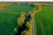 Aerial view of a picturesque rural farmstead with a river winding through the lush green landscape