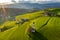 Aerial view of picturesque valley with chapel in Bolzano at sunset, Trentino, amazing green meadows of the mountains of Italy,