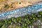 Aerial view of pine tree woods and a stream in a mountain