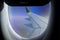 Aerial view from plane window with airplane wing and Andean mountain range below