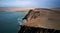 Aerial view of Playa Roja cliffs in Paracas, Peru - brown sand, golden rocks, green water,