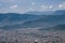 Aerial view of Pokhara city in Nepal with dense houses on the mountain hills.