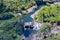 Aerial view, pond and waterfall. Surrounded by rainforest. Rocky banks. Hilo, Hawaii.