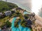 Aerial view of pool, umbrellas, sandy beach with green Palm trees. Coast of Indian ocean at sunset in summer. Zanzibar