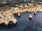 Aerial view of Praia da Marinha and Praia da Mesquita with natural arch at sunrise along the coastline in Lagoa, Faro, Algarve