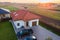 Aerial view of a private suburban house with parked cars in back yard