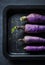 Aerial view of purple daikon radishes on black plate