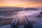 Aerial view of railroad bridge in fog at sunrise in autumn