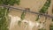 Aerial view of railway metal bridge over dirty river with muddy water in flooding period during heavy rains in spring.