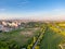 Aerial view of railway during sunset. City panorama in the background. Trees, grass and bushes in the foreground