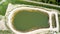 Aerial view of a rain retention basin at the edge of a new development, taken vertically