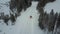 Aerial view of the red car on the road in the beautiful winter landscape of Lapland during a snowfall. Linear tracking of the car.