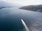 Aerial view of a red motor boat speeds by in the Kotor fjord in Montenegro.