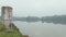 Aerial view reflective foggy lake with an empty metal silo on a grassy hill