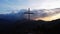Aerial view of a religious Christian steel cross on a hill in the mountainous countryside, in sunset