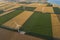 Aerial view of renewable windmills turbines supplying cultivation area with eco power getting energy from wind blowing on vast