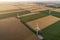 Aerial view of renewable windmills turbines supplying cultivation area with eco power getting energy from wind blowing on vast