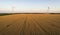 Aerial view of renewable windmills turbines supplying cultivation area with eco power getting energy from wind blowing on vast