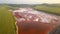 Aerial view of a reservoir full of red toxic sludge