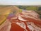 Aerial view of a reservoir full of red toxic sludge