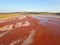 Aerial view of a reservoir full of red toxic sludge